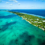 Kiribati é um país soberano composto por 33 ilhas, com atóis e recifes espalhados por uma vasta área ao centro do oceano Pacífico