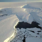 Uma plataforma de gelo da Antártida Ocidental, dividindo-se em torno de um ponto de fixação em sua frente de desprendimento