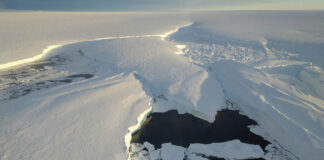 Uma plataforma de gelo da Antártida Ocidental, dividindo-se em torno de um ponto de fixação em sua frente de desprendimento