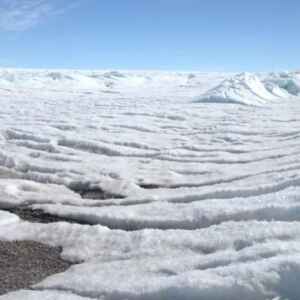 Antártida registra crescimento recorde de massa de gelo entre 2021 e 2023 Dois pesquisadores em trajes de proteção em uma paisagem de gelo na Antártida.