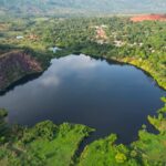 Serra Pelada brilha novamente com turismo sustentável e comunitário Lago azul profundo cercado por vegetação verde em Serra Pelada, com uma vila no topo da colina ao fundo