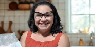 Mulher sorridente segurando um pacote de pirarucu congelado da marca Gosto da Amazônia.