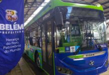 Transporte mais limpo: setor apresenta plano para cortar 68% das emissões de CO₂ até 2050 Ônibus elétrico verde e azul da Higer, com a inscrição 'Belém Prefeitura' em um banner ao lado, em uma parada de ônibus.