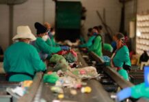 A virada verde do Brasil: Decreto federal obriga uso de plástico reciclado em embalagens Trabalhadores em uma linha de montagem de reciclagem, usando máscaras e luvas, classificam e separam lixo reciclável.