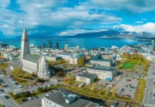 Islândia lidera ranking global de desenvolvimento humano e oferece lições ao Brasil Vista aérea de Reykjavík, Islândia, com a Igreja Hallgrímskirkja em destaque, a cidade e o oceano ao fundo.
