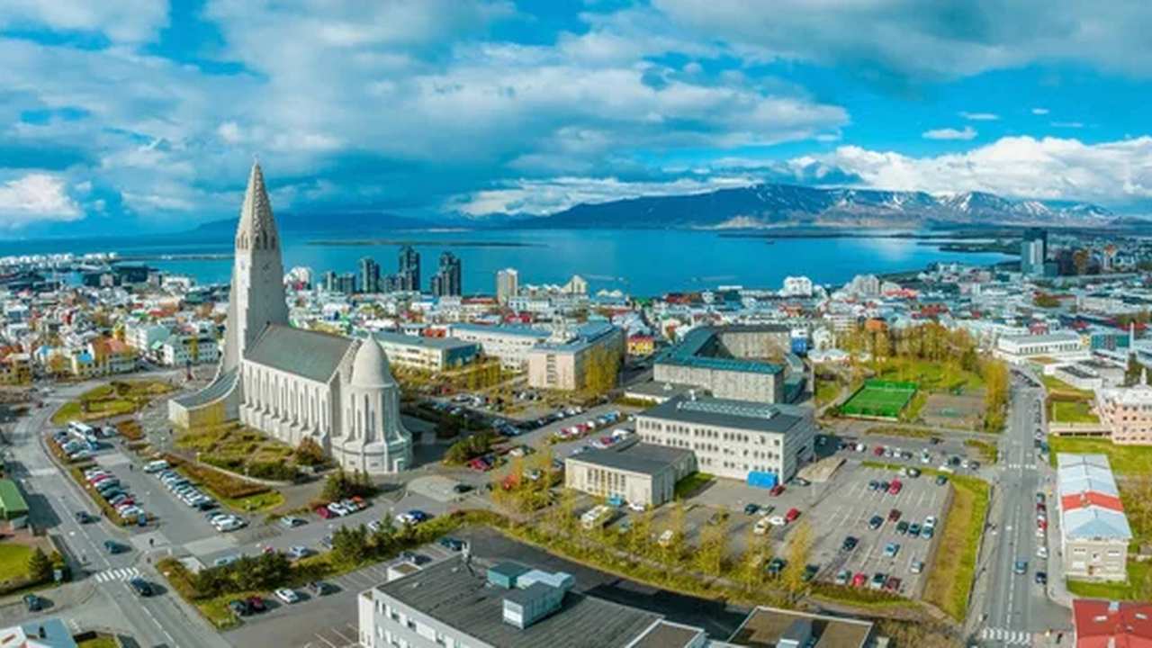 Islândia lidera ranking global de desenvolvimento humano e oferece lições ao Brasil 1 Vista aérea de Reykjavík, Islândia, com a Igreja Hallgrímskirkja em destaque, a cidade e o oceano ao fundo.