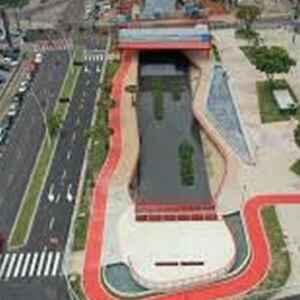 Potencial da bioeconomia atrai investimentos e transforma a Amazônia Vista aérea de um parque urbano com um canal de água, áreas verdes e ciclovias, mostrando um design moderno e integrado à cidade.