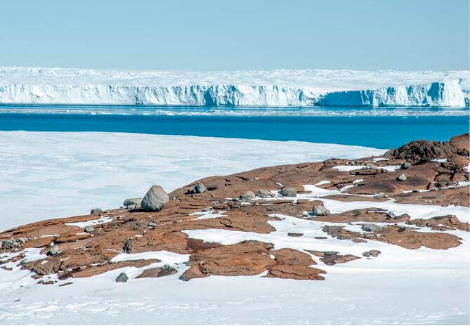 Vista através do leito rochoso para o término da Geleira Vanderford, Terra de Wilkes, Antártida Oriental