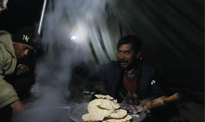 Carregadores de gelo fotografando as mudanças climáticas no rio Chadar congelado 6 Cozinhando no acampamento após um longo dia de trekking em Chadar