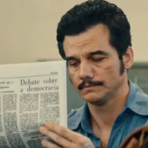 Wagner Moura e o segredo do lítio que o Brasil tentou esconder nos anos 70 Marcelo (Wagner Moura) lê jornal no instituto de identificação, em "O Agente Secreto" • Reprodução
