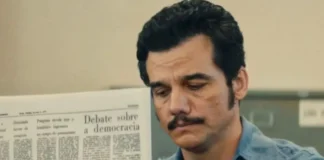Wagner Moura e o segredo do lítio que o Brasil tentou esconder nos anos 70 Marcelo (Wagner Moura) lê jornal no instituto de identificação, em "O Agente Secreto" • Reprodução