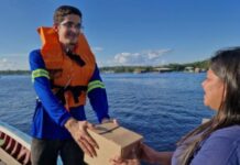 Empresa manauara leva case de logística fluvial da Amazônia à Logistique 2026 Funcionária da Navegam Log entrega uma encomenda em embarcação na Amazônia
