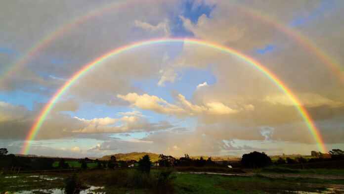 arco-iris-ceu-apos-chuva-foto-amadora-celular Arco-íris colorido no céu depois da chuva com nuvens abertas e luz dourada de fim de tarde