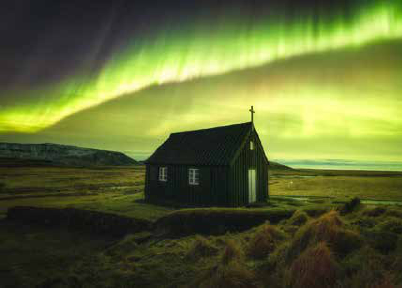 Um tubarão de poeira no céu vence o prêmio de astrofotografia 2 The Crown, vencedora da categoria Auroras. A igreja de madeira isolada na paisagem islandesa sob a aurora boreal, durante a tempestade geomagnética de 20 de janeiro de 2026.