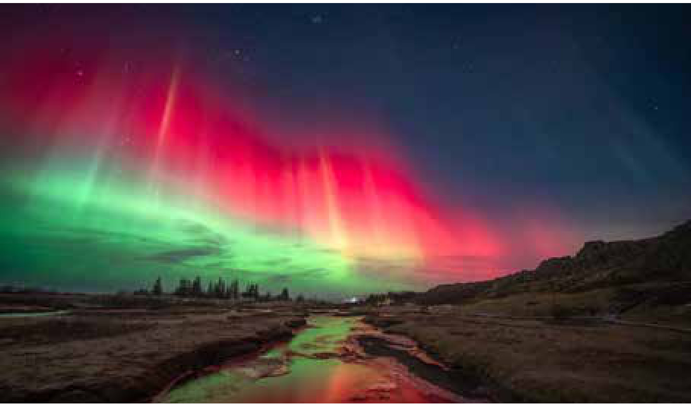 Um tubarão de poeira no céu vence o prêmio de astrofotografia 3 Aurora Between Two Continents, segunda colocada em Auroras. O riacho de Þingvellir, na Islândia, devolve as cores do céu na noite de 12 de novembro de 2025.
