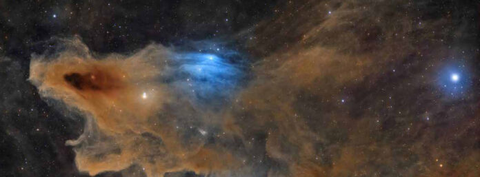 Um tubarão de poeira no céu vence o prêmio de astrofotografia Nebulosa escura LDN 1235, a Nebulosa do Tubarão, em tons de laranja e azul