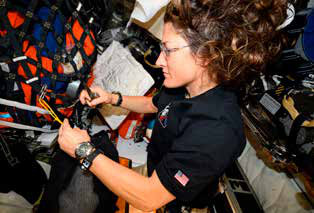 O que os astronautas ensinam sobre o sono na Terra 4 A astronauta Christina Koch trabalha dentro da cápsula Orion durante a missão Artemis II, em abril de 2026. No pulso, ela usa um monitor de movimento e sono do estudo ARCHeR, da NASA.