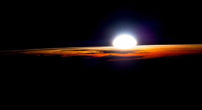 O que os astronautas ensinam sobre o sono na Terra Nascer do sol visto da Estação Espacial Internacional, com a curva da Terra iluminada em laranja sobre o espaço escuro