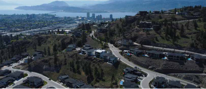 Mapas finos de calor mostram onde plantar árvores nas cidades Vista aérea de Kelowna, no Canadá, com loteamentos nas encostas e o lago Okanagan ao fundo