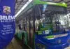 Transporte mais limpo: setor apresenta plano para cortar 68% das emissões de CO₂ até 2050 Ônibus elétrico verde e azul da Higer, com a inscrição 'Belém Prefeitura' em um banner ao lado, em uma parada de ônibus.