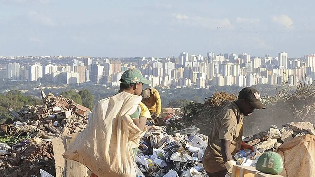 trabalhadores-catando-lixo-em-um-lixao-com-uma-cidade-ao-fundo-20250521000357 Governo revoga decreto de importação de resíduos recicláveis após mobilização de catadores